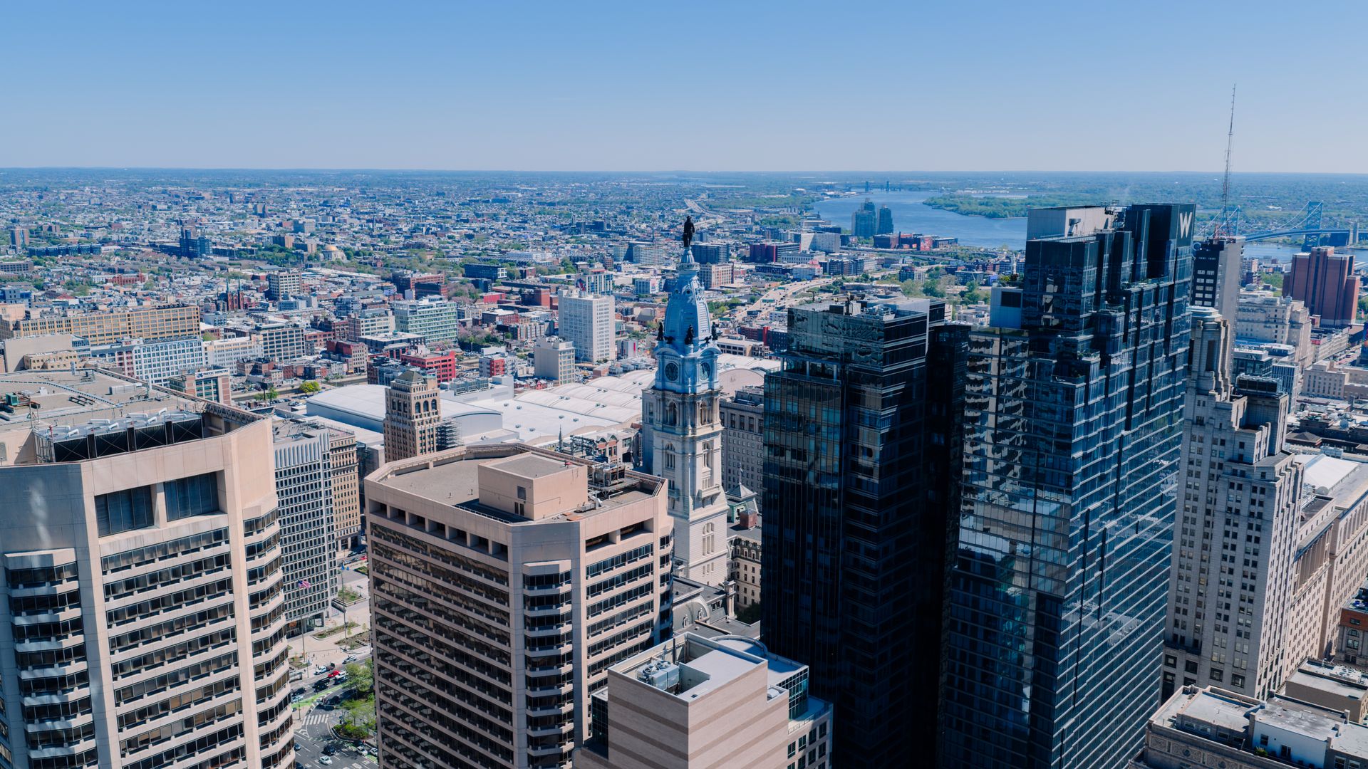 Aerial view over Philadelphia rooftops toward City Hall and the Delaware River