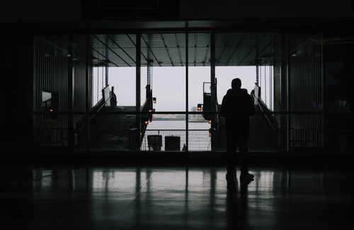 Free A silhouette of a person standing at a ferry terminal in New York City, highlighting transportation and travel themes. Stock Photo