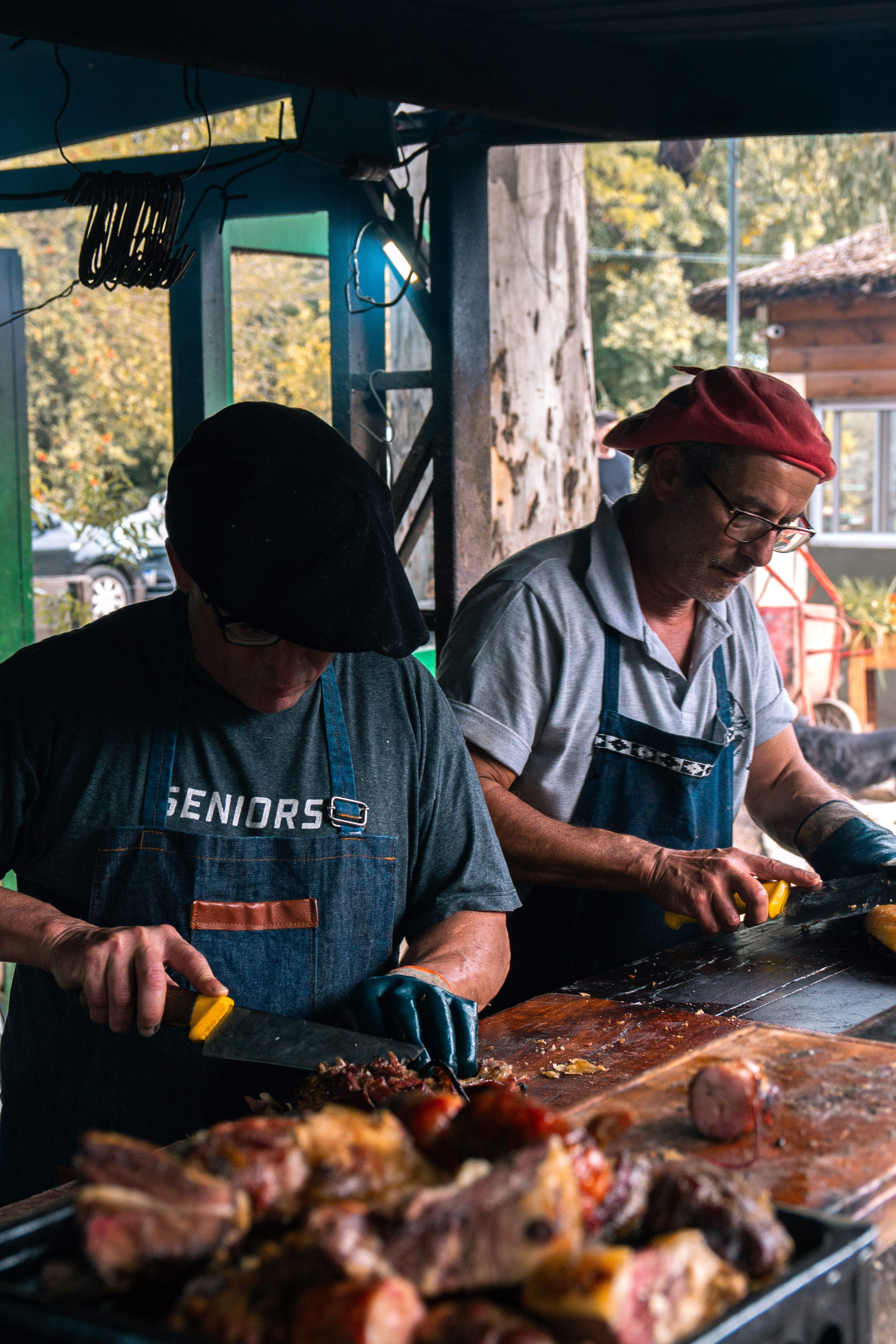 Two chefs carving barbecue in an outdoor market