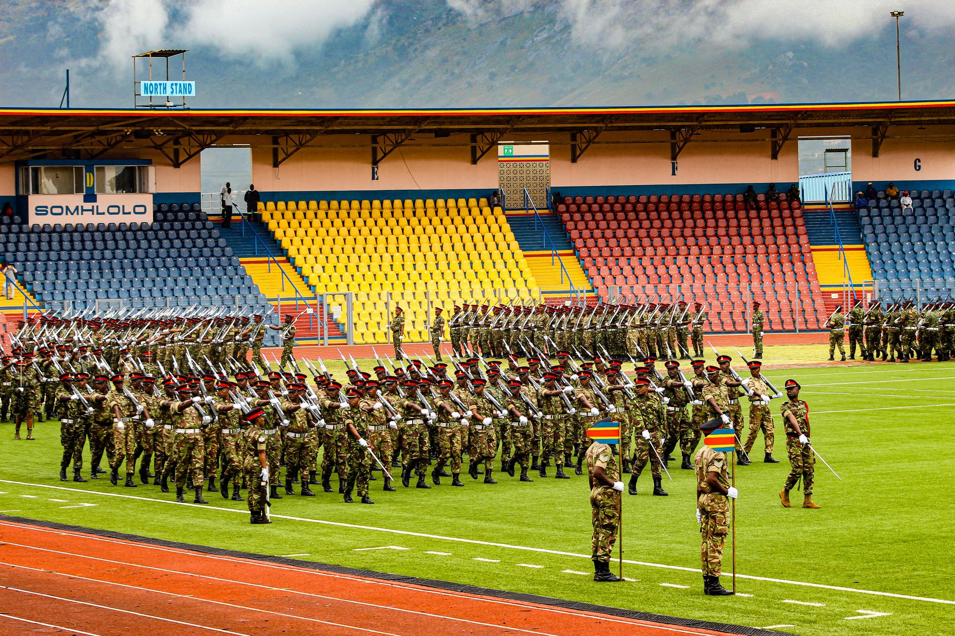 Soldiers in uniform parade at Somhlolo Stadium, Eswatini showcasing discipline and unity.