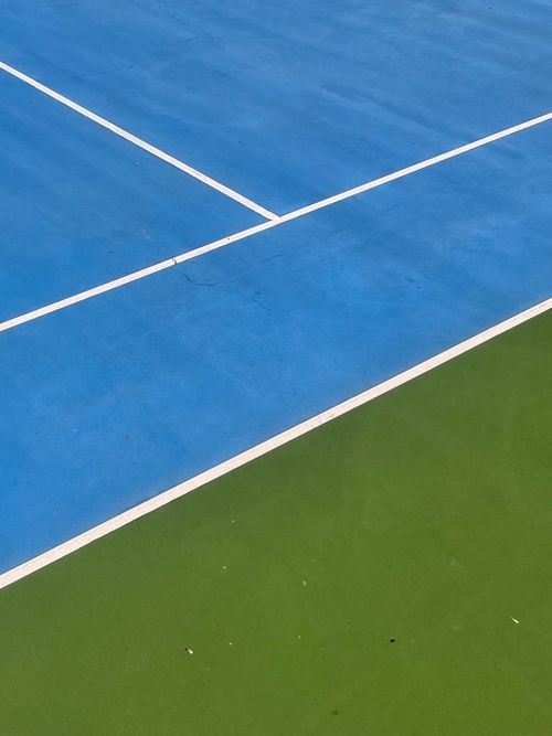 Free A vivid view of tennis court lines showcasing blue and green colors, ideal for sports-themed visuals. Stock Photo