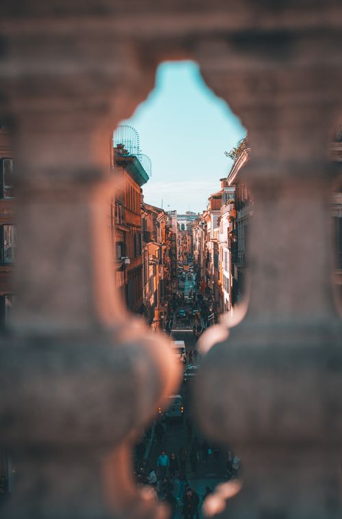Free Discover the beauty of a historic European street through an ornate archway, showcasing vibrant city life. Stock Photo