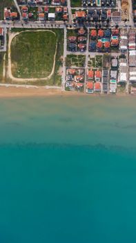 Stunning aerial view of residential area by the beach with calm turquoise waters.