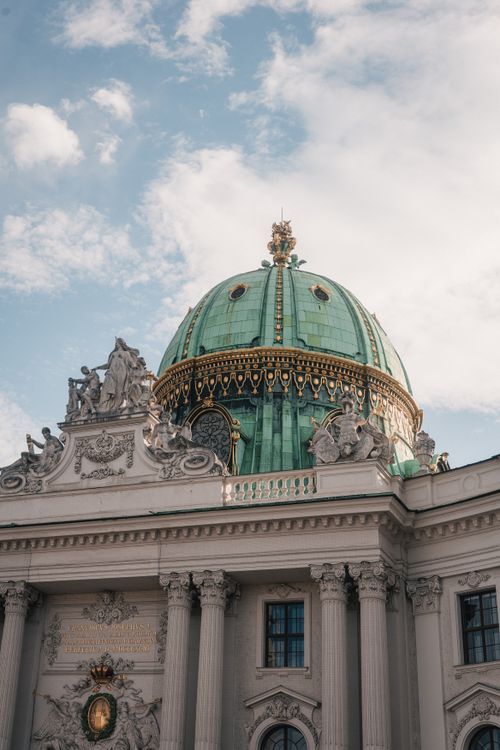 Free Captivating architectural detail of the Hofburg Palace's green dome under a blue sky in Vienna, Austria. Stock Photo