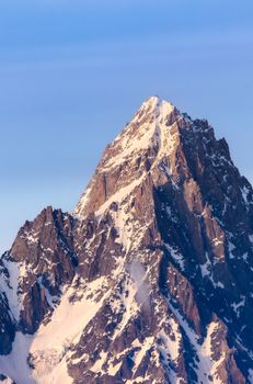 Breathtaking view of a snow-capped mountain peak at sunset, capturing the serene beauty of the Alps.
