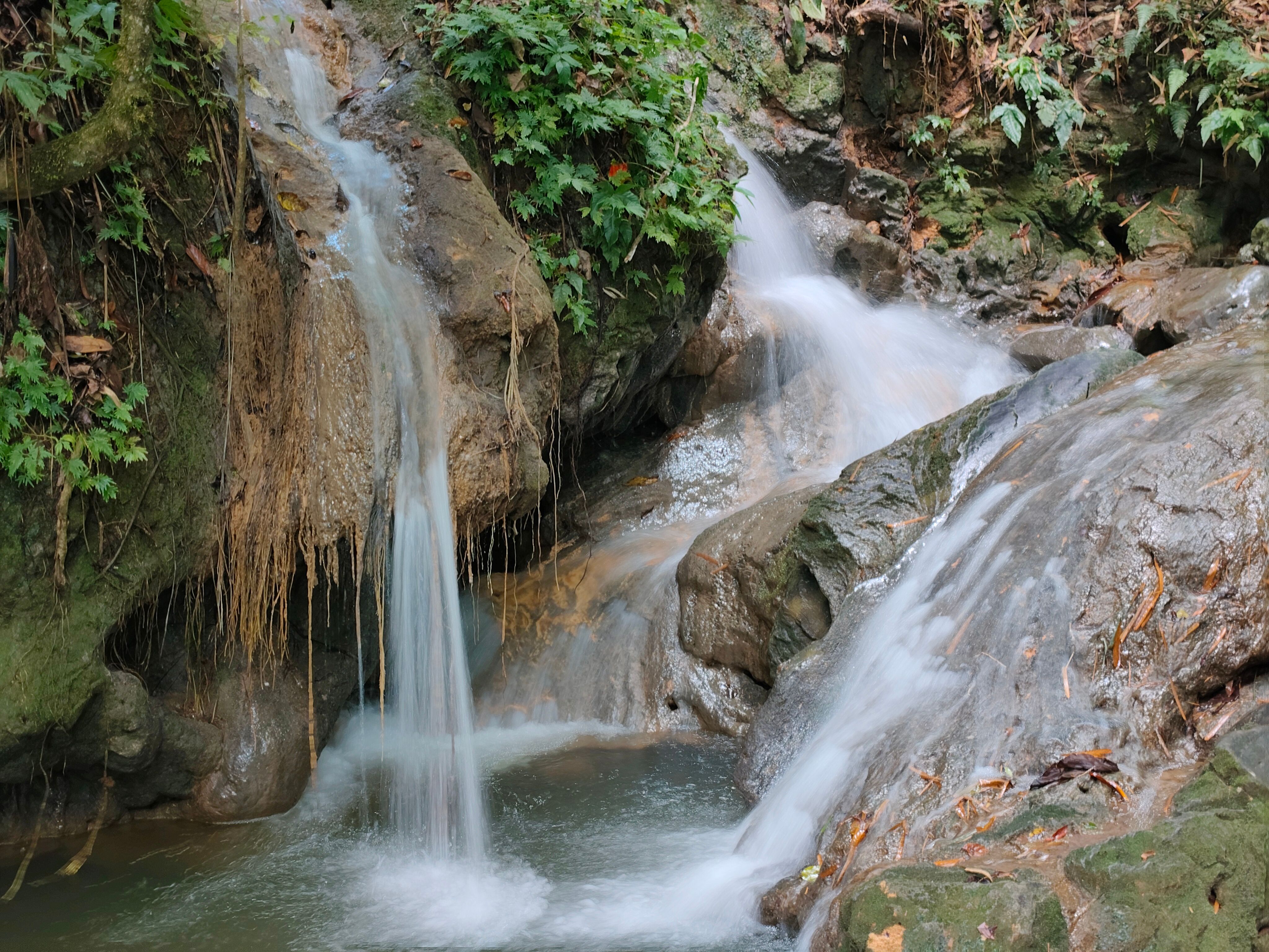 Sticky Waterfalls limestone cascades with people climbing wet rock faces