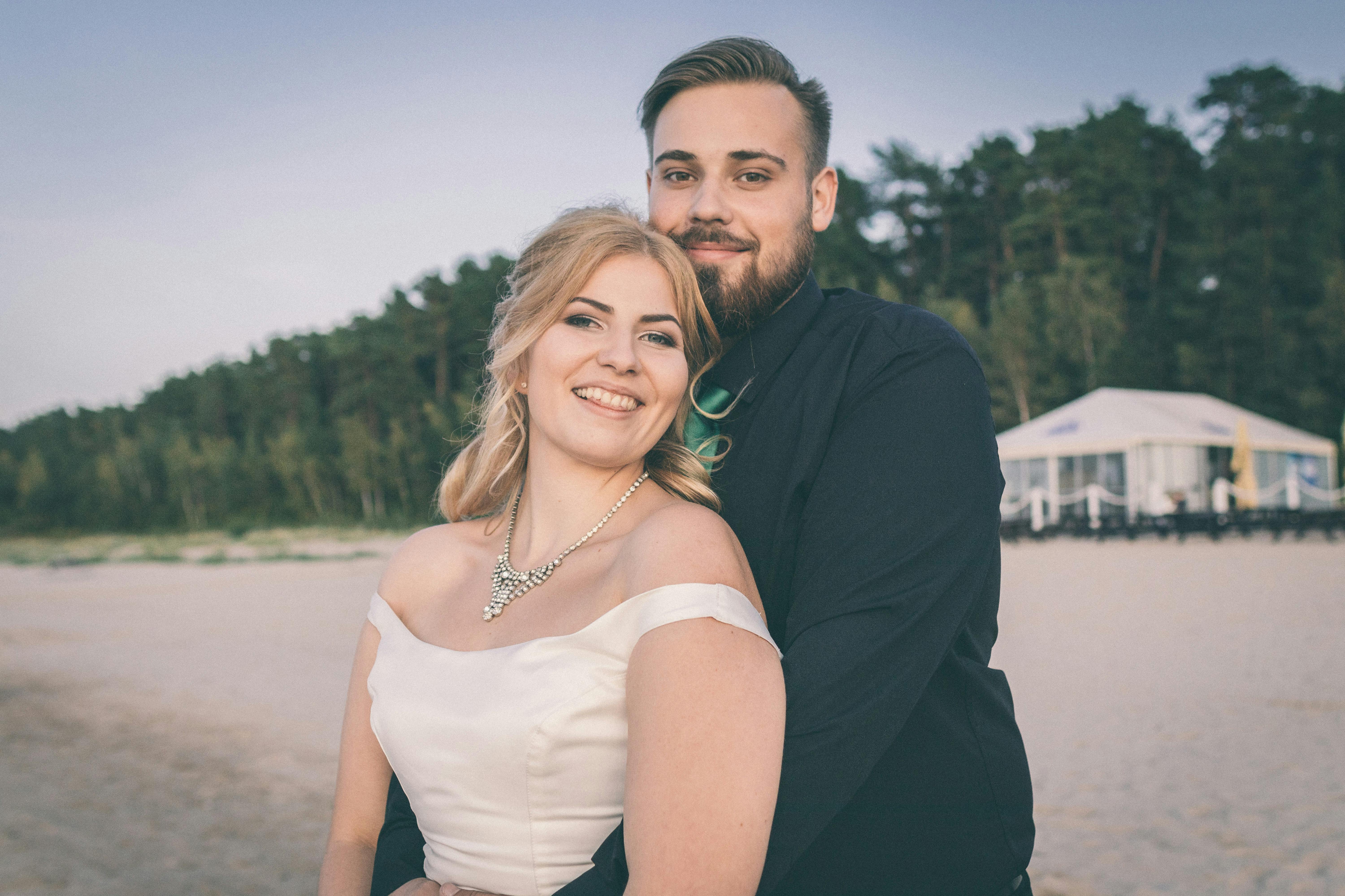 一对快乐的情侣在海滩上拥抱，捕捉亲密的婚礼时刻