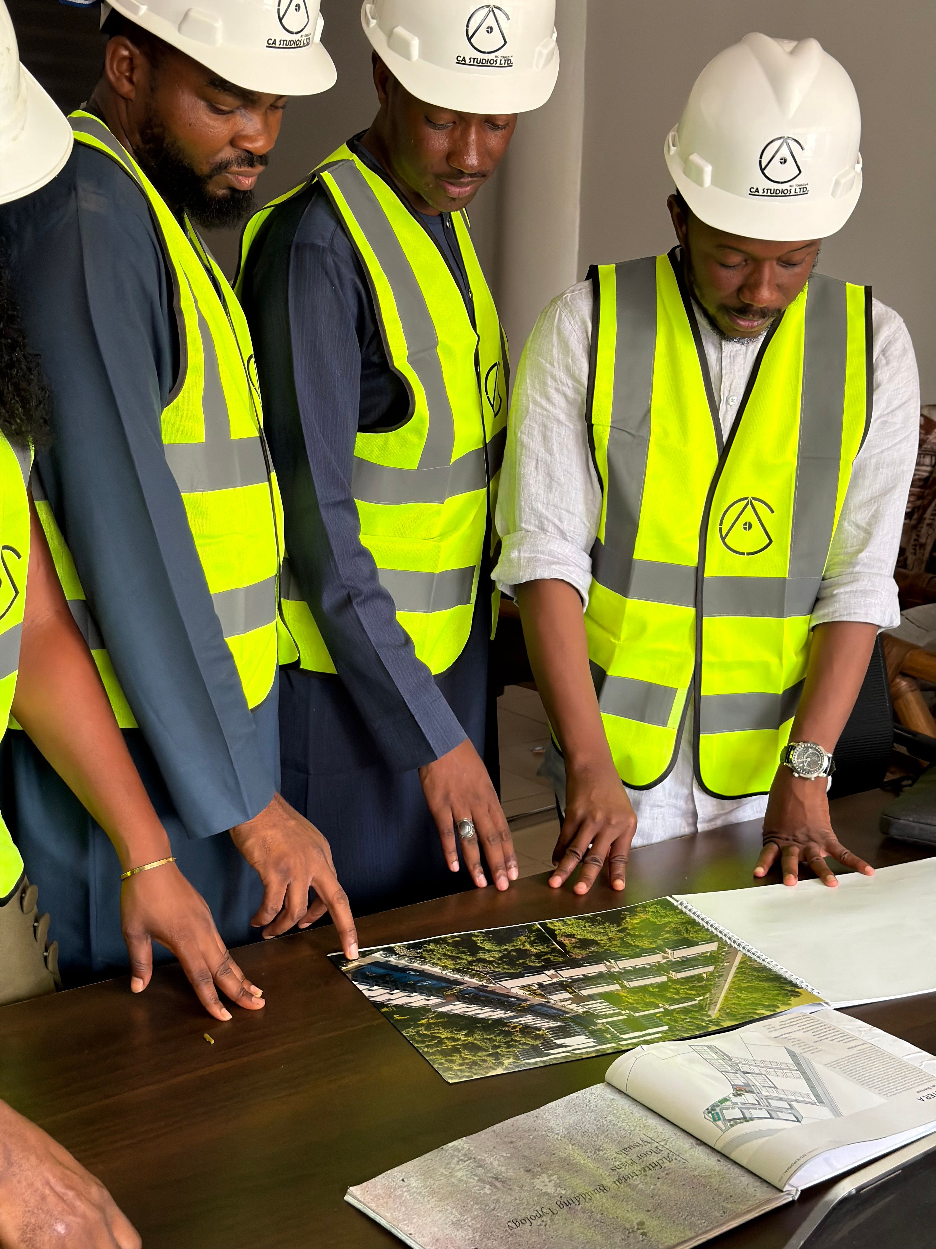 Team Reviewing Construction Plans at Site Meeting · Free Stock Photo