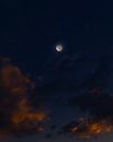 一轮新月高悬在布满星星的宁静天空中，非常适合夜空爱好者观赏