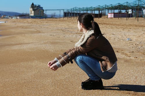 Free Woman Crouching on Brown Sand Stock Photo