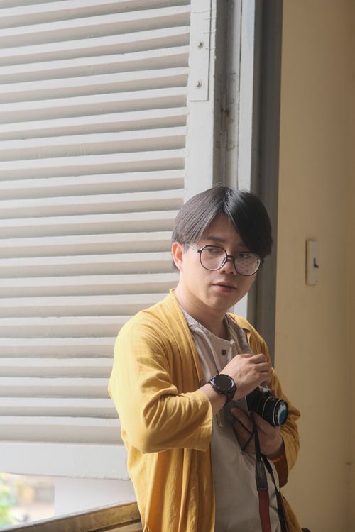 Free A thoughtful man in Hue, Vietnam, captured with a camera in hand indoors. Stock Photo
