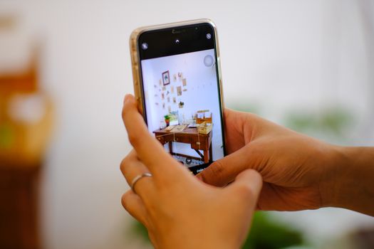 Close-up of taking an artistic workspace photo with a smartphone in Hue, Vietnam.