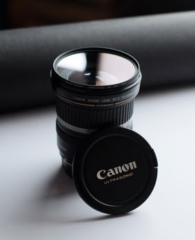 Isolated Canon camera lens with cap highlighting sleek design and modern photography equipment.