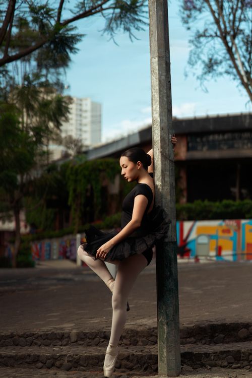 Free Ballet dancer in elegant pose outdoors with urban backdrop, showcasing grace and balance. Stock Photo