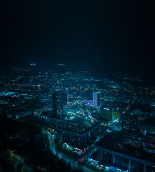 A stunning aerial view of Sarajevo's cityscape illuminated at night, showcasing vibrant city lights.