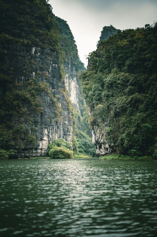 Free Explore stunning limestone cliffs under an overcast sky in Ninh Bình, Vietnam. Stock Photo
