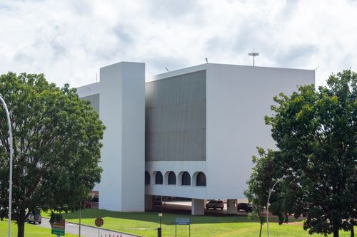 Free A modern white building surrounded by greenery in Brasília, showcasing sleek architectural design. Stock Photo