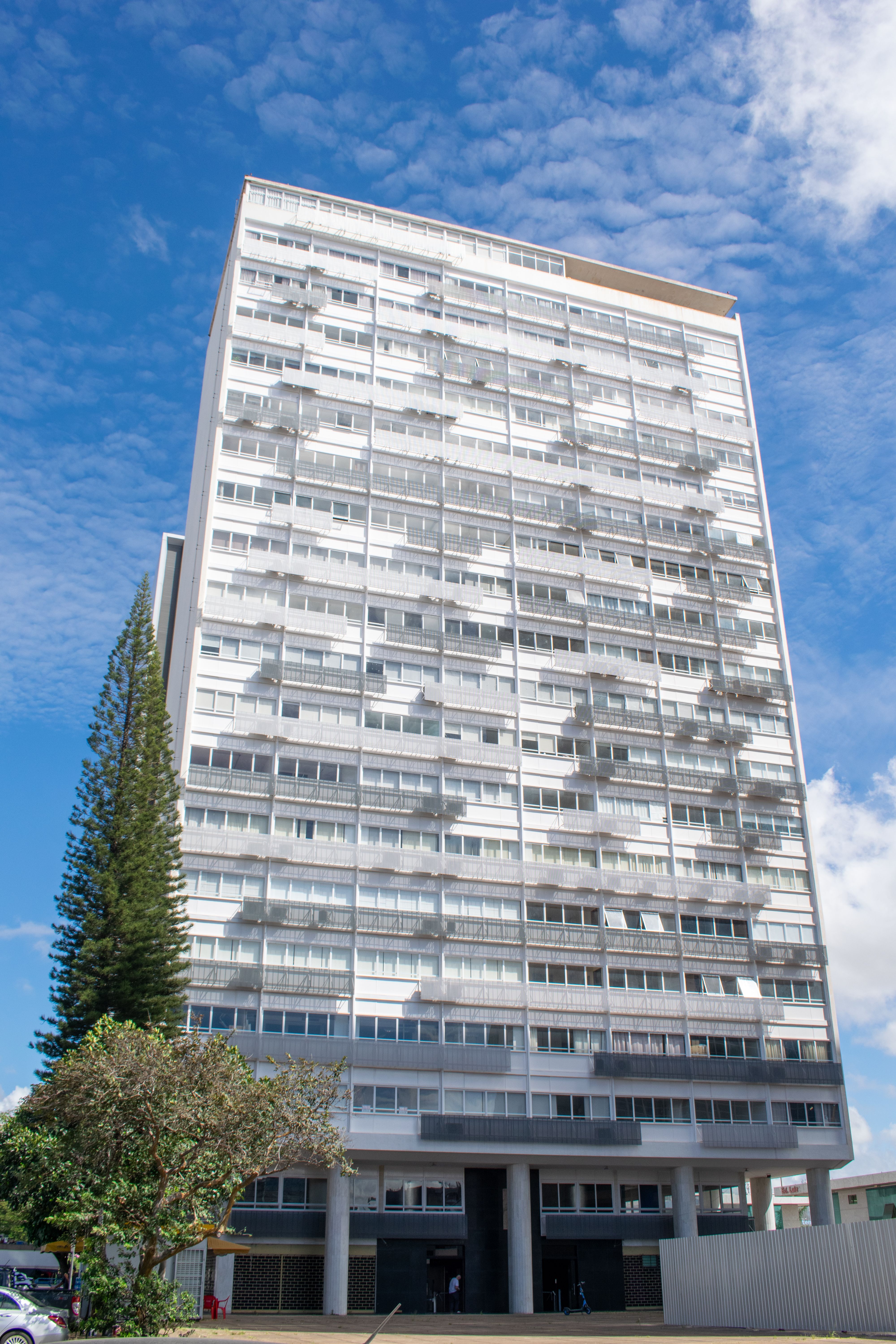 Stunning architectural view of a high-rise building against a vibrant blue sky in Brasília, Brazil.