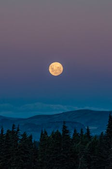 Serene view of the full moon rising over the mountains in San Carlos de Bariloche, Argentina.