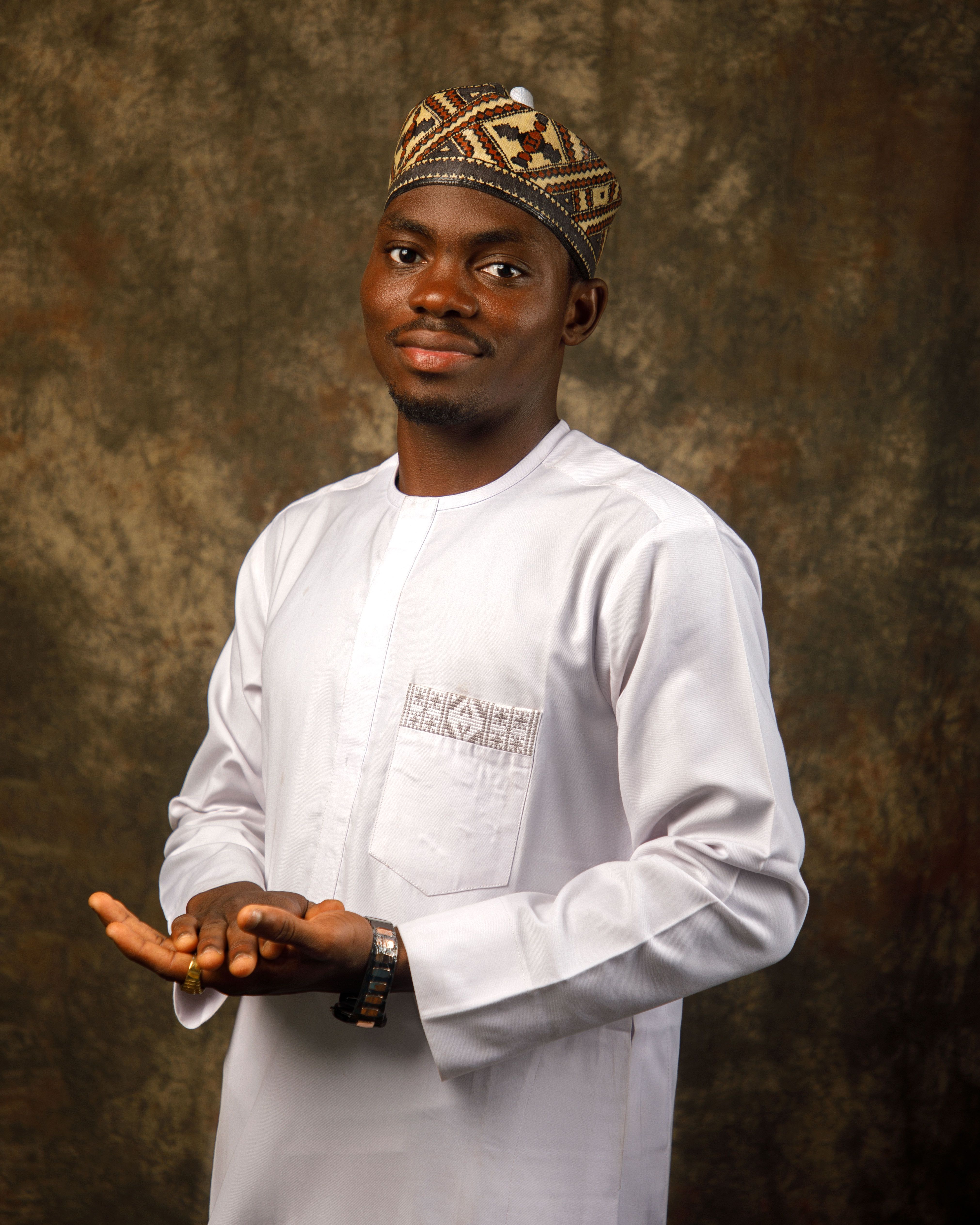 Smiling man in traditional African clothing poses against a textured background.