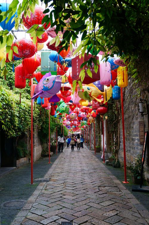 Free A picturesque alley adorned with colorful lanterns creates a vibrant scene, perfect for cultural exploration. Stock Photo