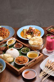 A vibrant display of traditional Indonesian cuisine, featuring rice, noodles, and satay. - Fotografer Sidoarjo