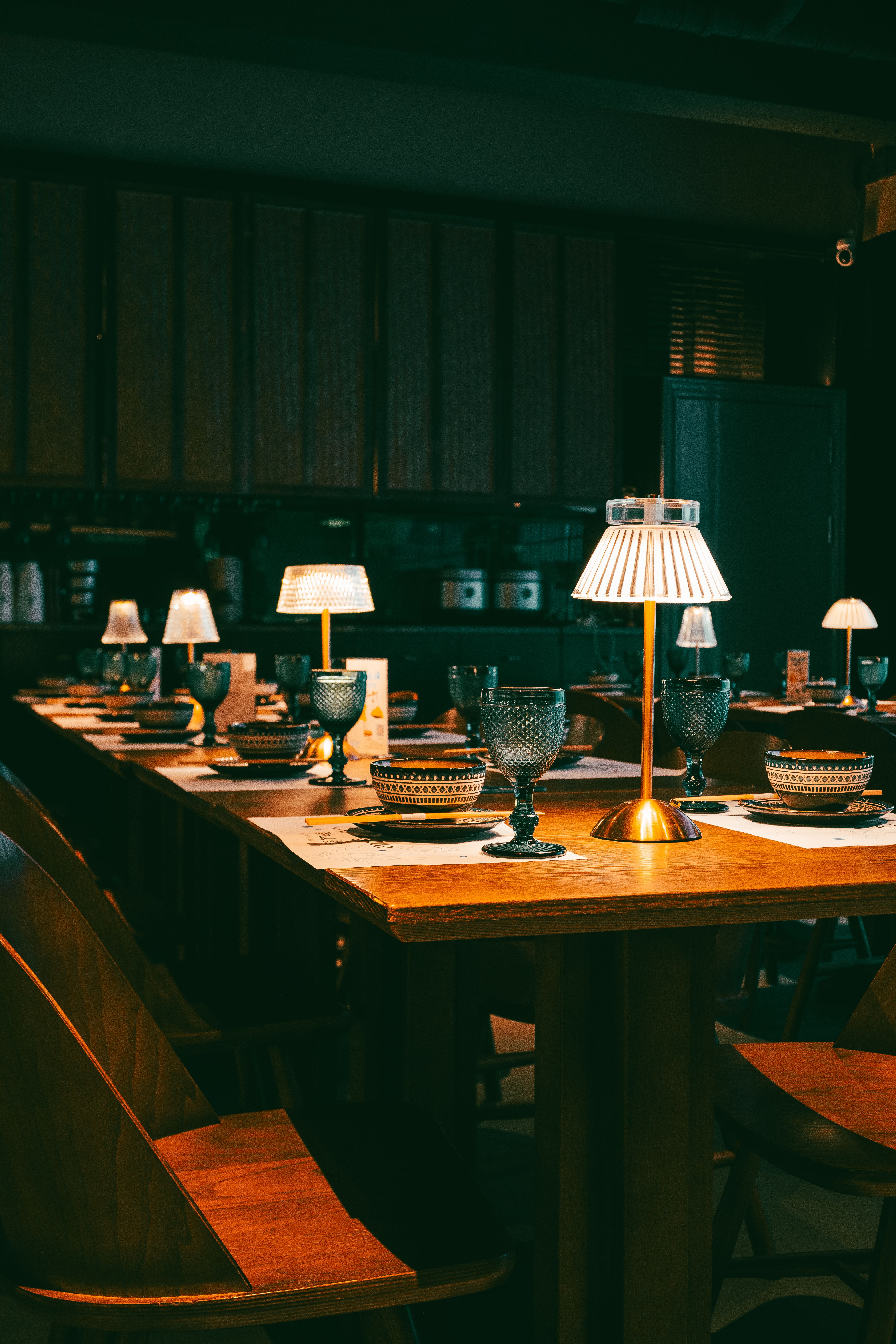 A set table at Iron Steak under warm lamplight, glasses polished and waiting for the evening