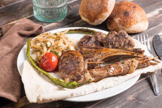 Tantalizing Turkish kebab served with grilled vegetables and fresh bread on a rustic table.