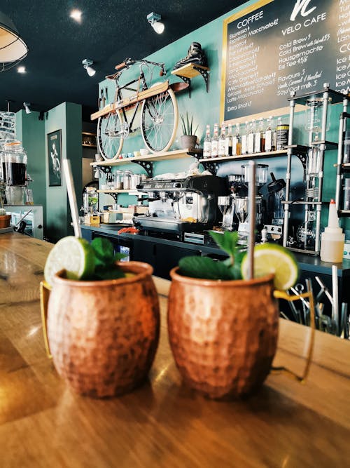 Fresh delicious mocktails in creative copper mugs composed on counter in modern light cafeteria