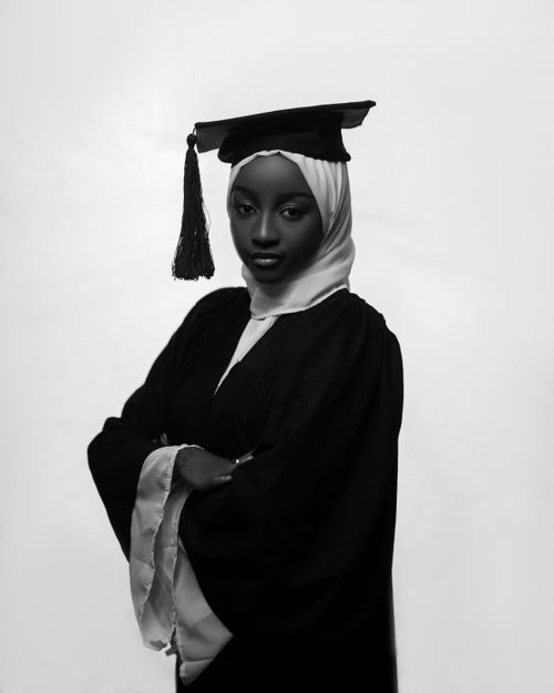Free Elegant black and white portrait of a young woman in a graduation cap and gown. Stock Photo