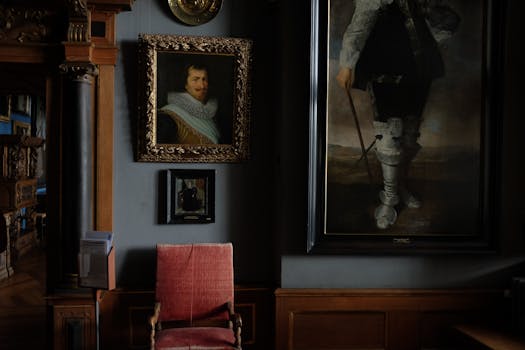 Interior of modern art gallery with portraits in cozy frames hanging on blue wall near comfy old chair