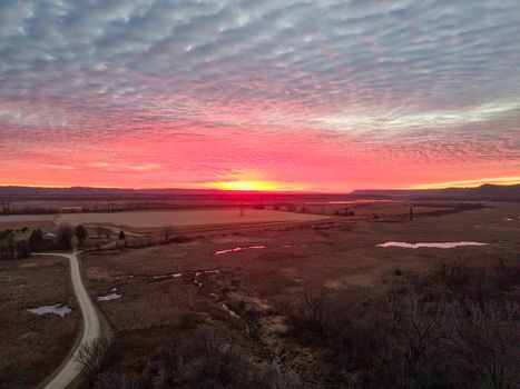 A vivid winter sunset over the rural landscapes of Kellogg, Minnesota, with dramatic clouds.