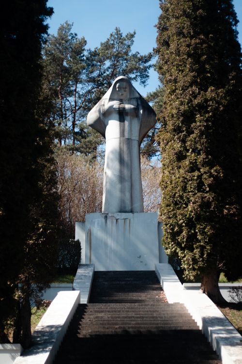 Free Statue of a hooded figure amidst trees, symbolizing memorial and history. Stock Photo