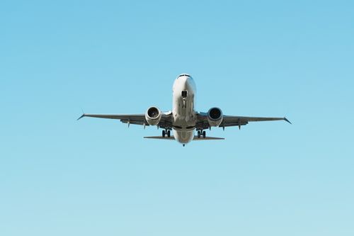 Free A front view of an airplane in flight against a clear blue sky, showcasing aviation. Stock Photo