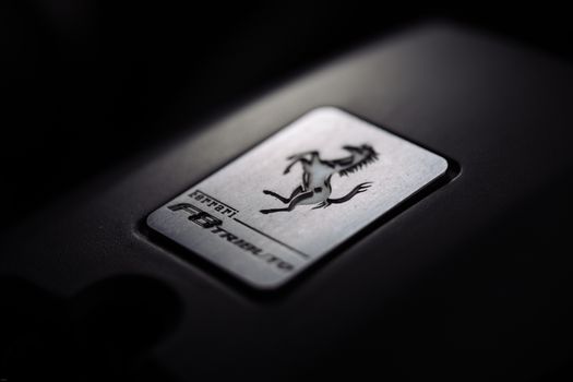 Close-up of a metallic car logo badge with a prancing horse, symbolizing luxury and speed.