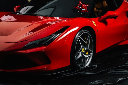 Free Close-up shot of a sleek red sports car with branded gloves on the dashboard. Ideal for luxury automotive themes. Stock Photo