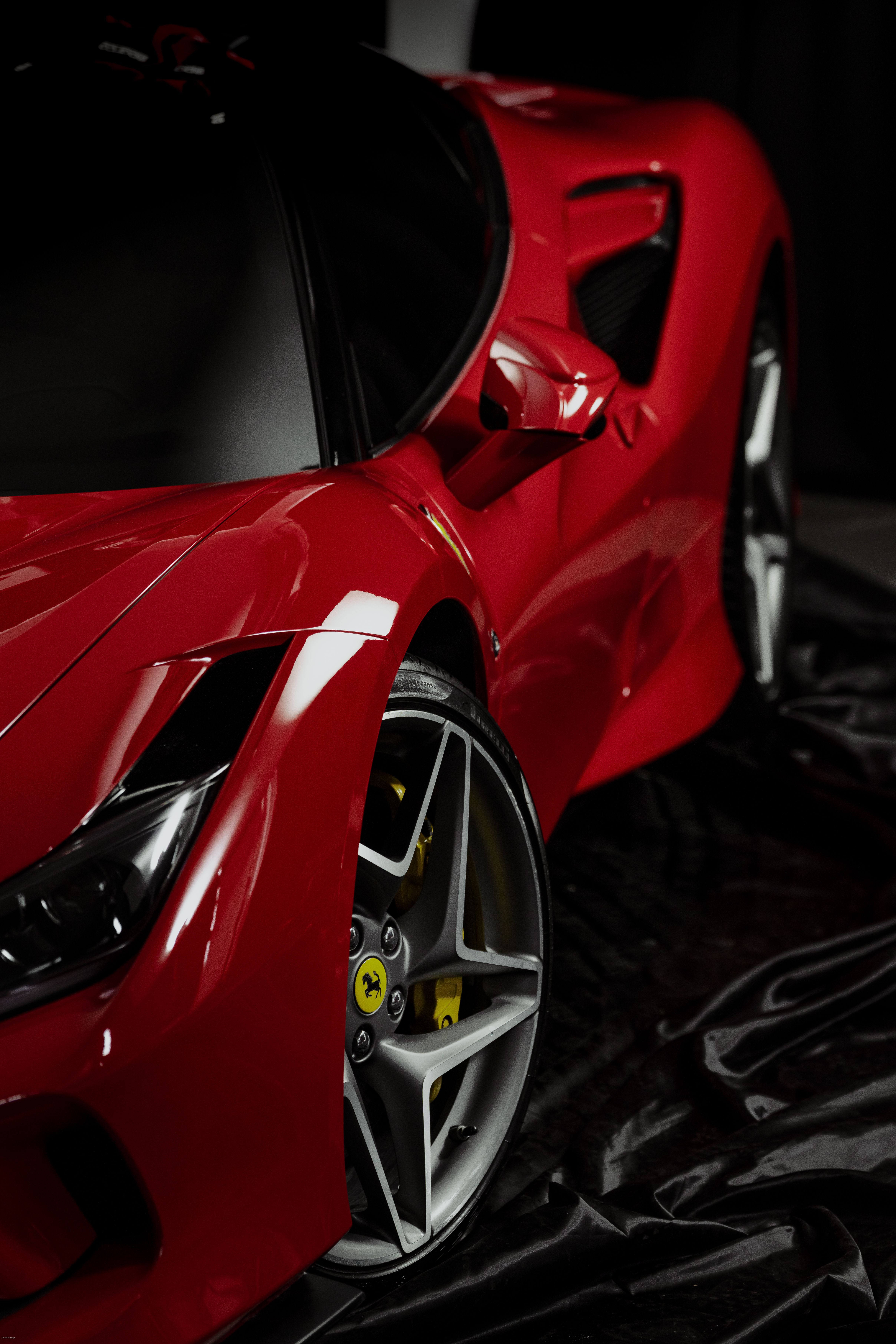 Detailed close-up of a glossy red sports car showcasing elegance and style.
