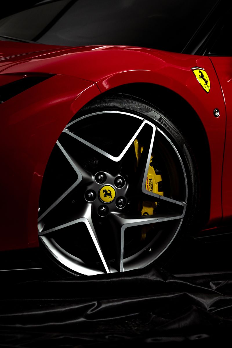 Detailed view of a red sports car wheel featuring a recognizable logo and sleek design.