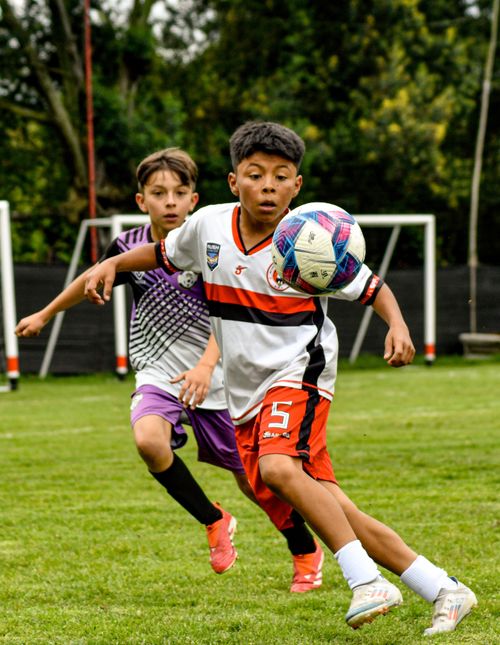 Free Two young boys playing soccer, focusing intently on the ball during a match. Stock Photo