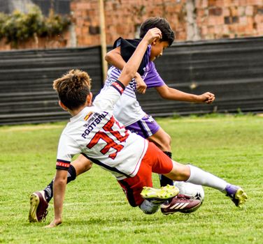 Action-packed soccer match with young boys in dynamic play on a green field.