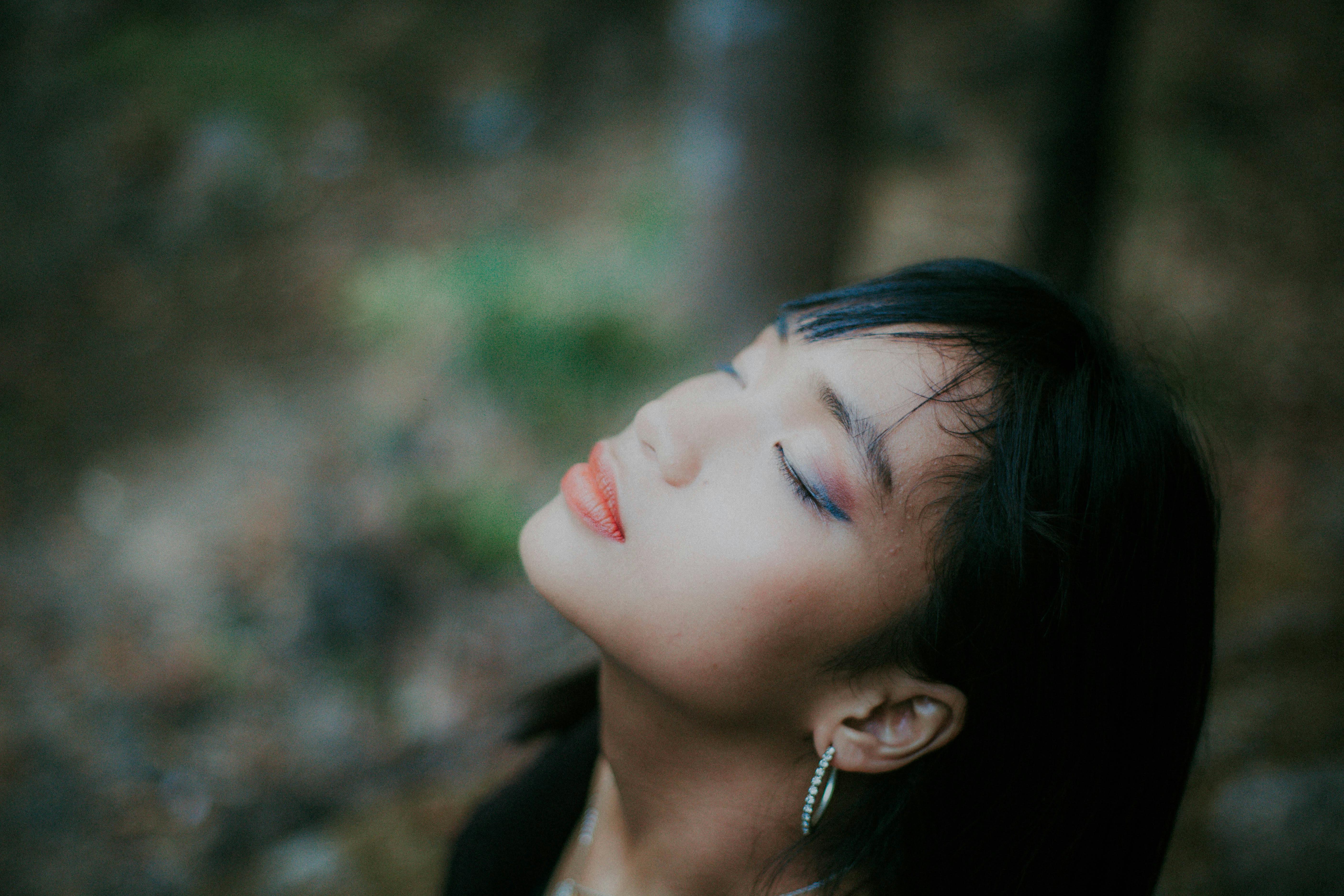一幅描绘闭眼拥抱自然的女性平静肖像