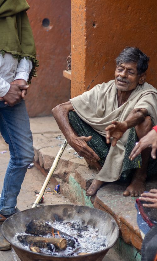 Free Candid capture of locals warming near an open fire on a street corner, depicting everyday life. Stock Photo