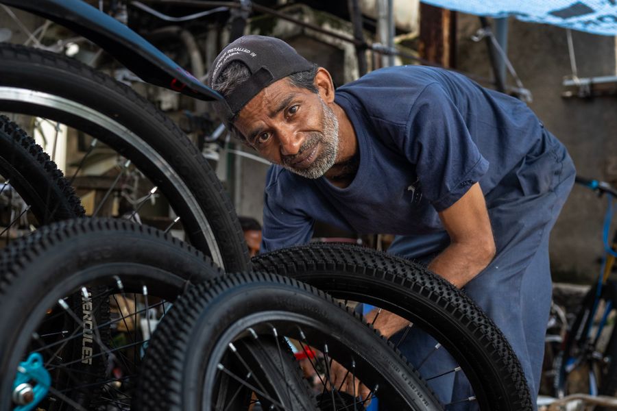 A mechanic working on a bicycle wheel
