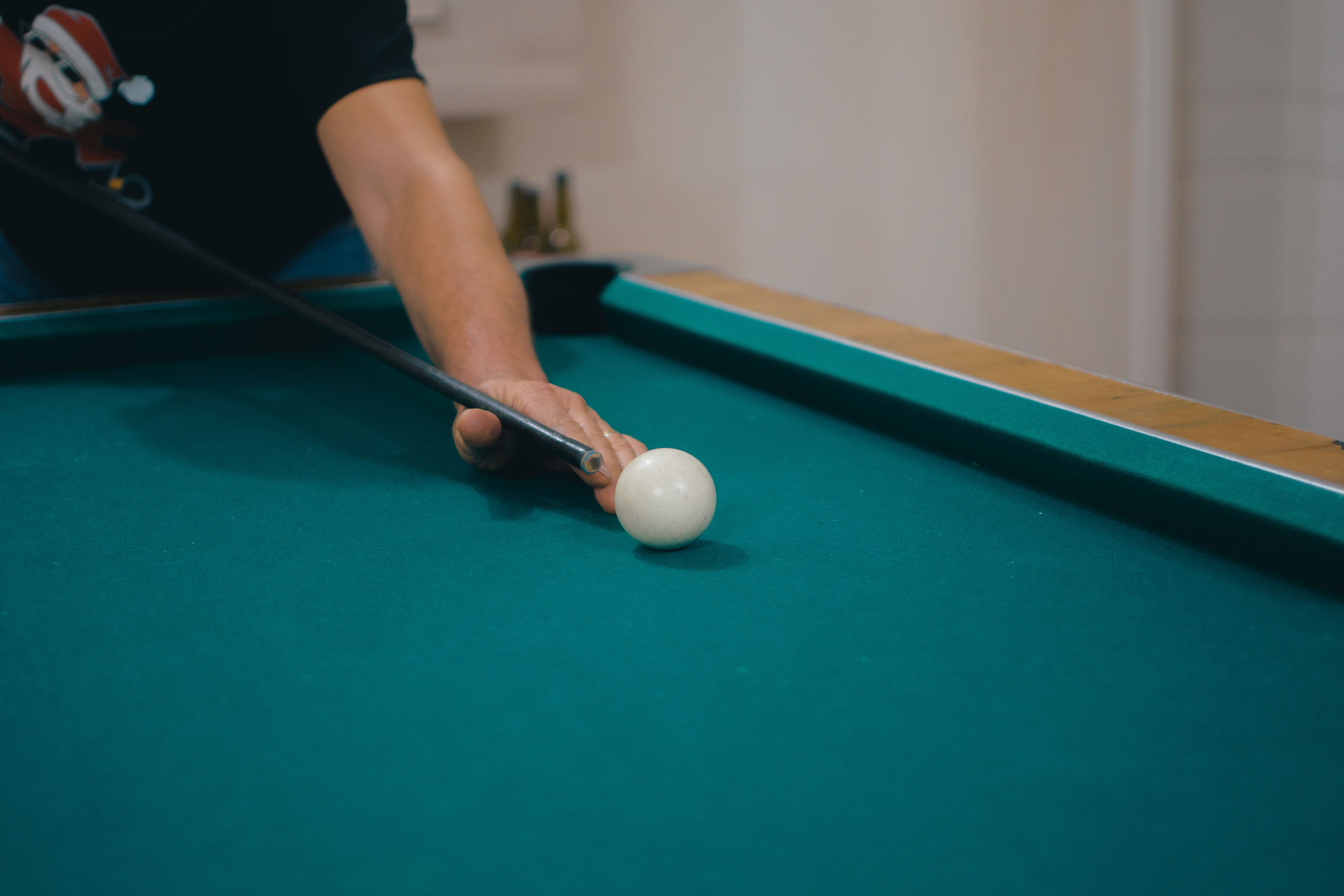 man playing billiards with focus on white ball