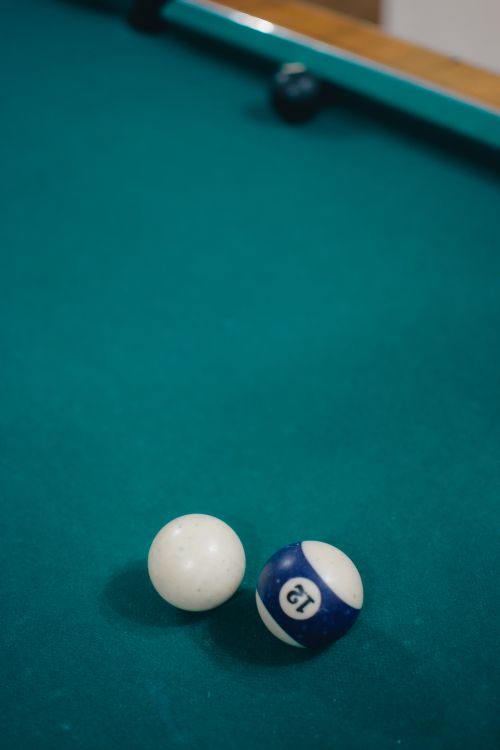 Free Detailed view of cue and 12 ball on green billiard table, perfect for leisure concepts. Stock Photo