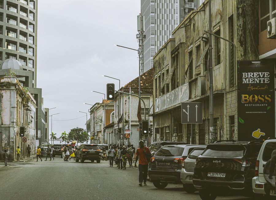 Bustling street scene in downtown Luanda, Angola with historic and modern buildings.