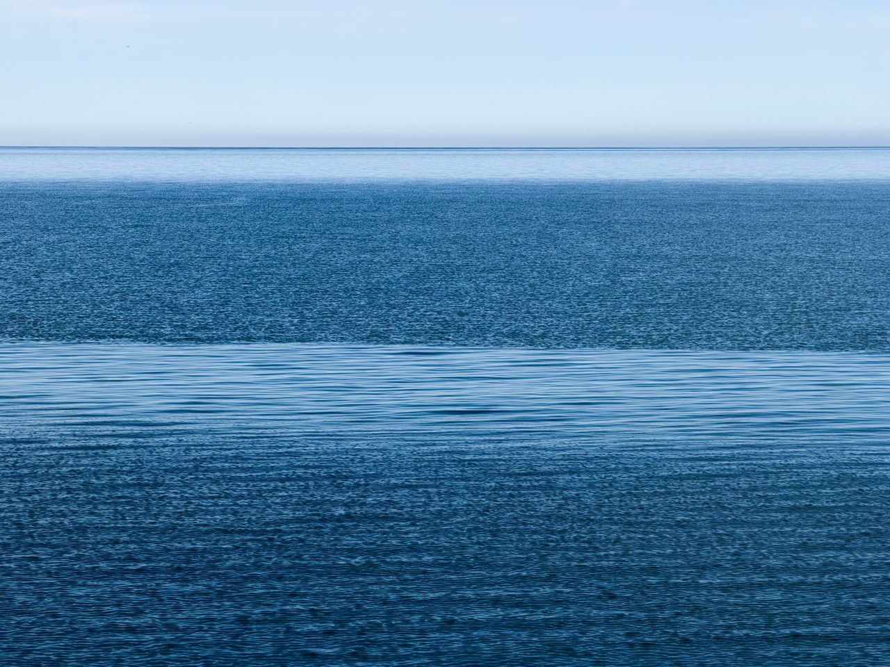 a tranquil view of the calm ocean under a clear blue sky capturing ser