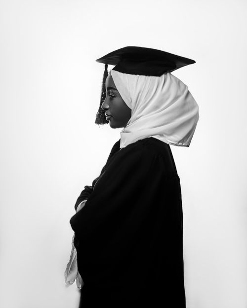 Free A side profile portrait of a Muslim woman wearing a graduation cap and gown. Stock Photo