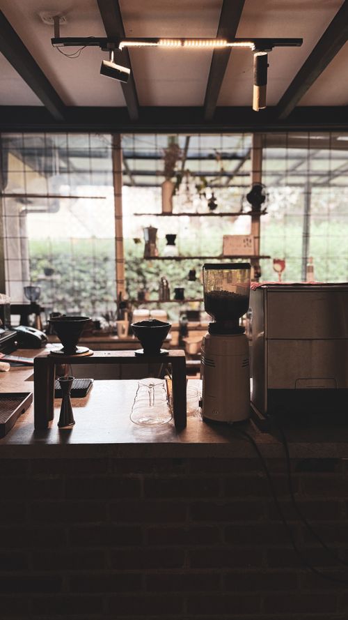 Free Cozy café interior in Bandung with coffee brewing setup, offering a warm ambiance for coffee enthusiasts. Stock Photo