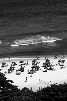 Black and white aerial photo of beachgoers relaxing on a sunny day in Rio de Janeiro, Brazil.